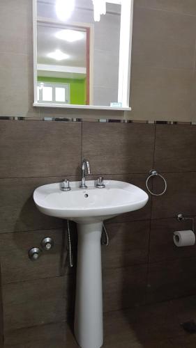 a bathroom with a white sink and a mirror at Arbolada Talas del Tuyu in San Clemente del Tuyú