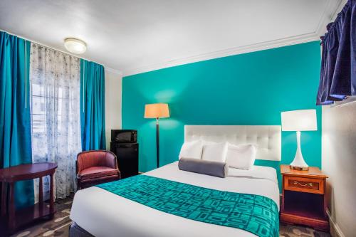 a hotel room with a bed and a blue wall at Howard Johnson by Wyndham Hershey in Hershey