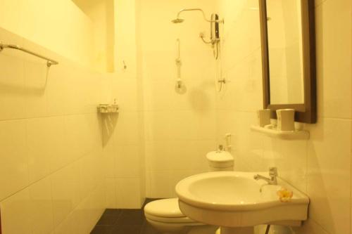 a white bathroom with a toilet and a sink at Pedlar 62 Guest House in Galle