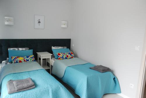 a room with two twin beds and a table at KAMI Ferienwohnungen in Pobierowo