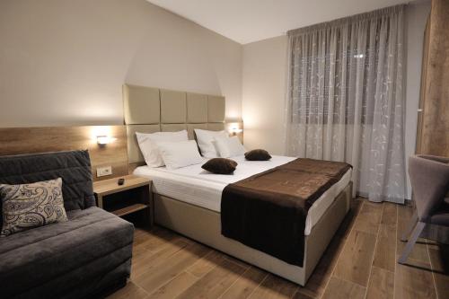 a bedroom with a large bed and a couch at Villa Divani in Mostar