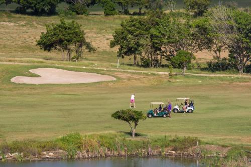 a group of people playing golf on a golf course at Blue Bay Villa's in Blue Bay