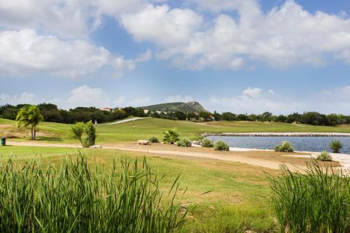 a golf course with a body of water and grass at Blue Bay Villa's in Blue Bay