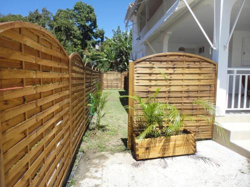 a wooden fence with plants in a backyard at Kouleur Karayib in Le Gosier