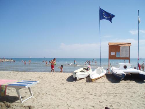 a group of people on a beach with boats at Lido delle Farfalle in Casalbordino