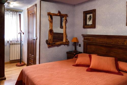 a bedroom with a bed and a mirror on the wall at Casa Rural el Sastre in Navaleno