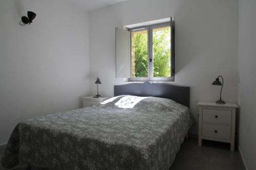 une chambre avec un lit et une fenêtre dans l'établissement La Caprine, à Gordes