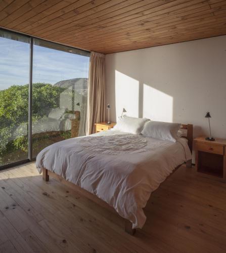 a bedroom with a large bed and a large window at OMZ - Olas de Matanzas in Matanzas