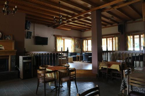 a dining room with tables and chairs and a fireplace at Hotel Elatofilito in Athamanio