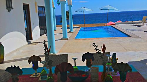 a house with a swimming pool next to the ocean at Villa Star of the Sea in Barra de Navidad