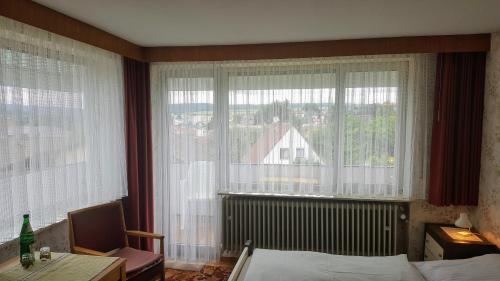 a bedroom with a bed and a large window at Gästehaus Fleck in Bad König