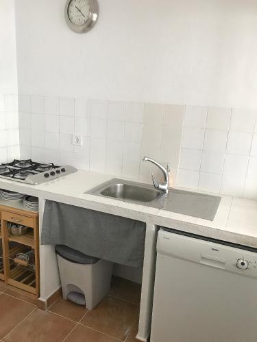 a kitchen with a sink and a clock on the wall at Casa Azul in Bolonia