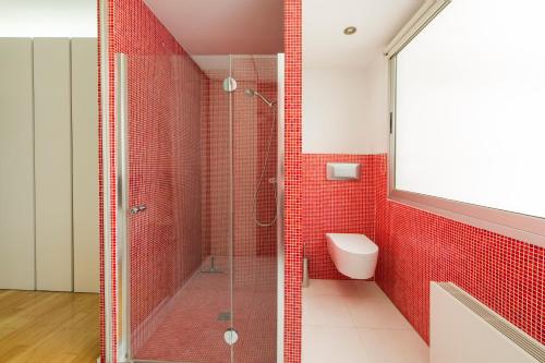 バレンシアにあるMD Art Apartment Ruzafaの赤いタイル張りのバスルーム(シャワー、トイレ付)