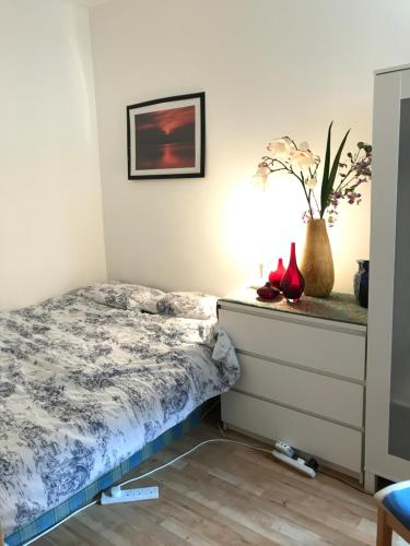 a bedroom with a bed and a nightstand with red shoes at Finchley Road in London