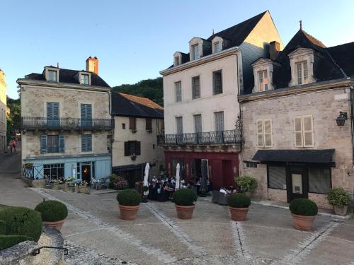 a group of buildings in a street with plants at Les Maisons du Périgord in Terrasson-Lavilledieu