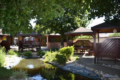 a garden with wooden gazebos and a pond at Hotel U Racka in Ostrožská Nová Ves