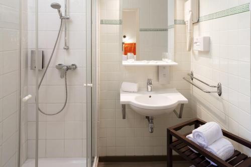 a bathroom with a sink and a shower at Logis Hôtel Restaurant Les Cèdres in Joyeuse