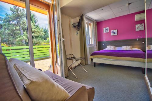 - une chambre avec un lit et un mur violet dans l'établissement Logis Hôtel Restaurant Le Chalet du Mont Roland, à Dole