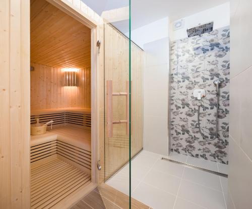 uma cabina de duche ao nível do chão com uma porta de vidro em Villa DIVINA em Rogoznica