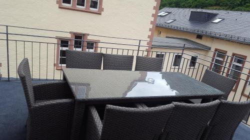 a table and chairs on a balcony with a building at Hotel Ravene in Cochem