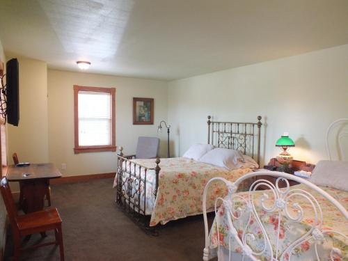 a bedroom with two beds and a table and a window at Scarborough Inn in Manteo