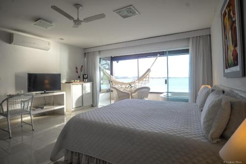 a bedroom with a bed and a view of the ocean at Barracuda Eco Resort Búzios in Búzios