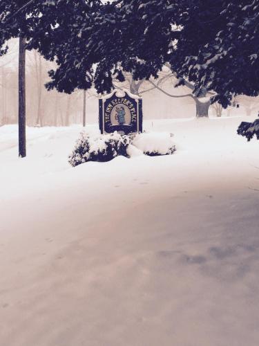 a sign covered in snow in a park at Innkeeper's Place B&B in Stafford Springs