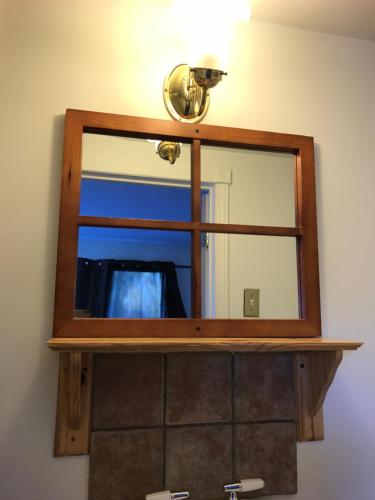 a mirror on a wall with a light on top at Objectif Santé in Longueuil