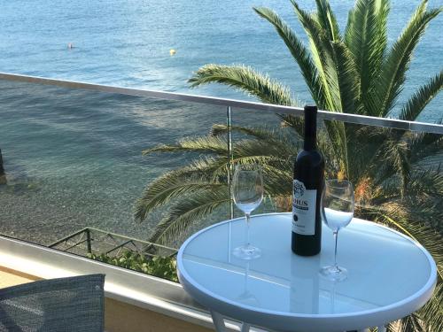a table with two glasses and a bottle of wine at Franovic Apartments in Tivat
