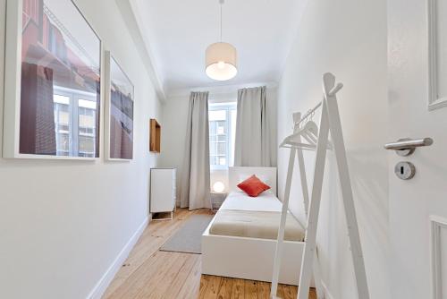 a small white room with a bed and a staircase at Sleep in Centre in Porto
