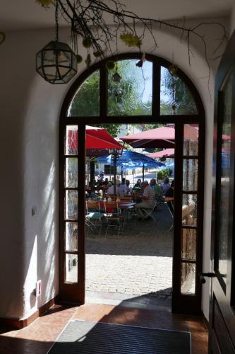 an open door to a patio with people sitting at tables at Bayerischer Hof in Burghausen