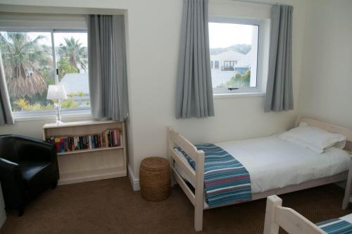 a small bedroom with a bed and two windows at 3 Spinnaker The Quays in Knysna