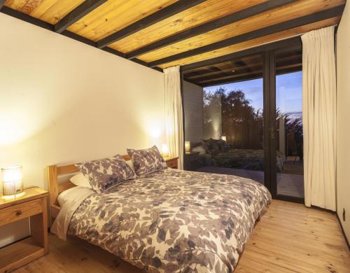 a bedroom with a bed and a large window at OMZ - Olas de Matanzas in Matanzas