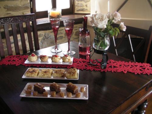 a table with two plates of pastries and glasses of wine at Iliopetra Suites in Agios Lavredios