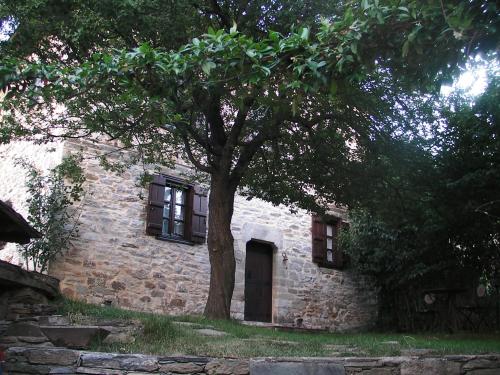 a brick house with a tree in front of it at Iliopetra Suites in Agios Lavredios