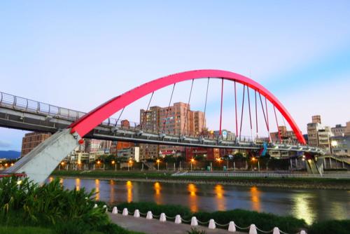 a red bridge over a river in a city at Hotel Lee-Chan in Taipei