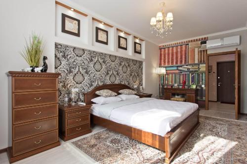a bedroom with a large bed and a dresser at Cozy Apartments in Arcadia in Odesa