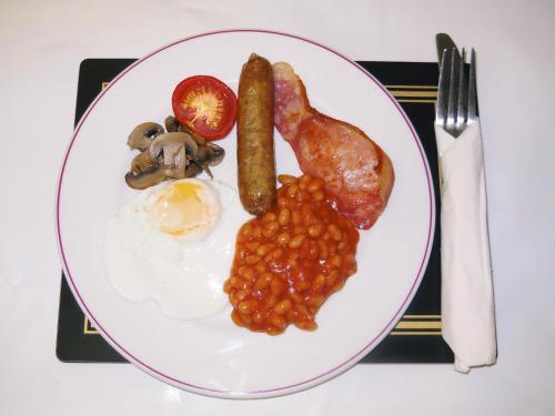 a plate of breakfast food with eggs beans and meat at The Oakland Hotel in Woodham Ferrers