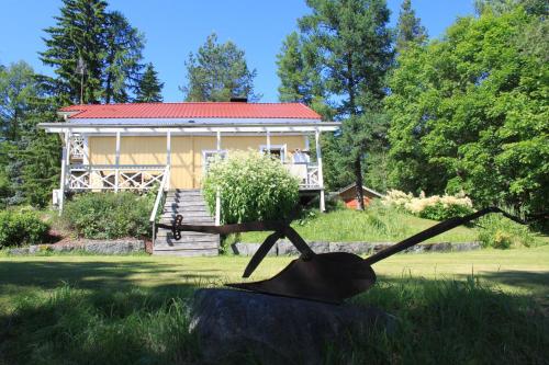 a statue in the grass in front of a house at Keitaanniemen lomamökki in Haapamäki