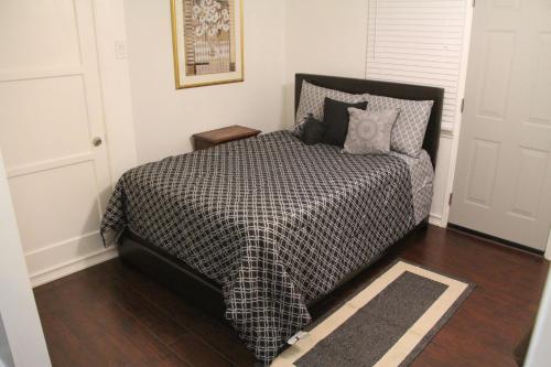 1 dormitorio con 1 cama con edredón blanco y negro en Summer Leaf, en Reseda