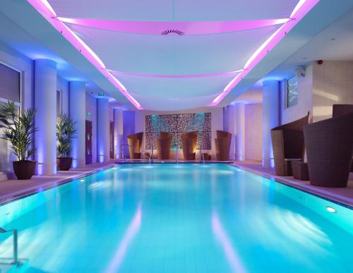 a swimming pool in a hotel with blue lighting at The Royal Yacht in Saint Helier Jersey