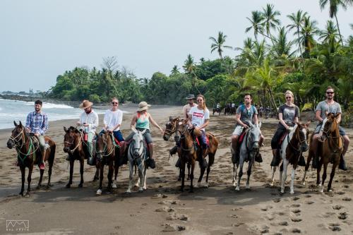 a group of people riding horses on the beach at Life for Life Hostel Drake Bay Home of Sea Turtle Marine Conservation Project Osa Peninsula near San Josecito Beach in Drake