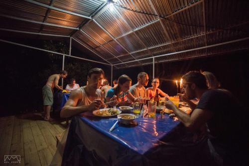 a group of people sitting around a table with food at Life for Life Hostel Drake Bay Home of Sea Turtle Marine Conservation Project Osa Peninsula near San Josecito Beach in Drake