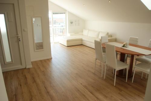 een woonkamer met een tafel en een witte bank bij Apartments Zelic in Vodice