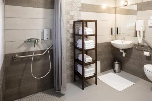 La salle de bains est pourvue d'une douche, d'un lavabo et de toilettes. dans l'établissement Logis Hôtel Restaurant Les Cèdres, à Joyeuse
