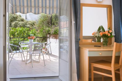 a door leading to a balcony with a table and chairs at Albergo Teresa in Laigueglia