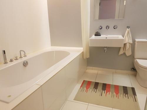 a white bathroom with a tub and a sink at Old Town Apartment in Tallinn