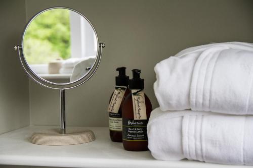 a mirror sitting on a counter next to two bottles of alcohol at Pennygate Lodge in Craignure