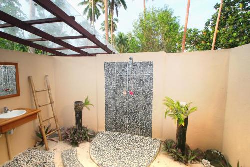 a bathroom with a shower with a sink at Mango Bay Resort in Namatakula