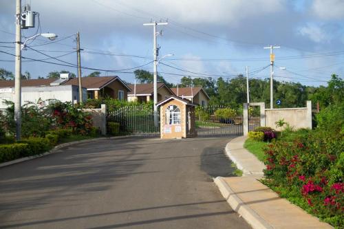 an empty street with a fence and a house at Cheerful 2-Bedroom Home in Falmouth Garden in Falmouth